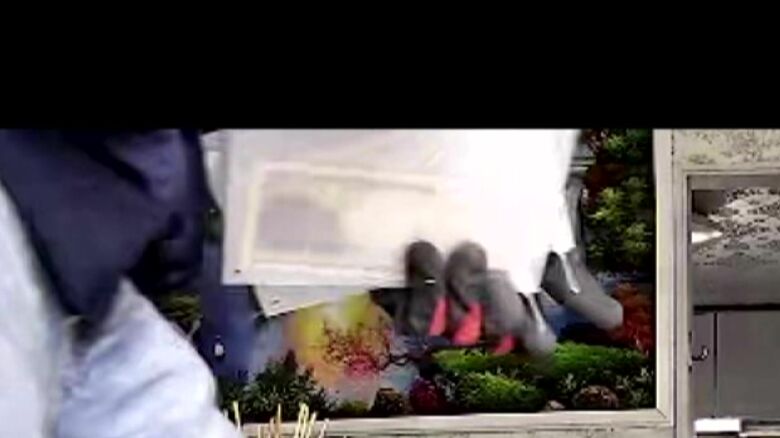 赤い手袋の男の手元にはお札（提供：被害者）