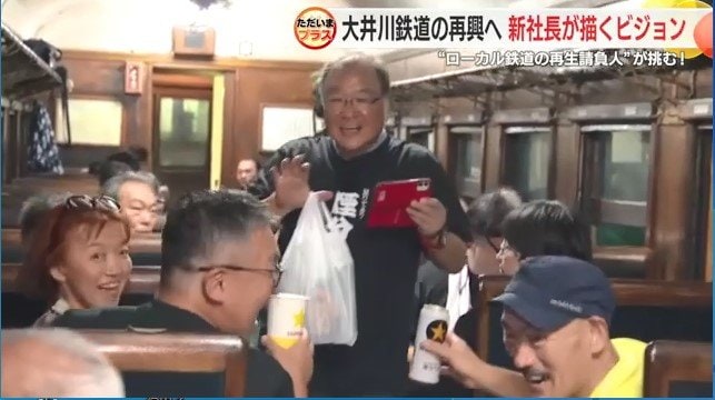 ビール列車内で乗客と談笑する鳥塚社長