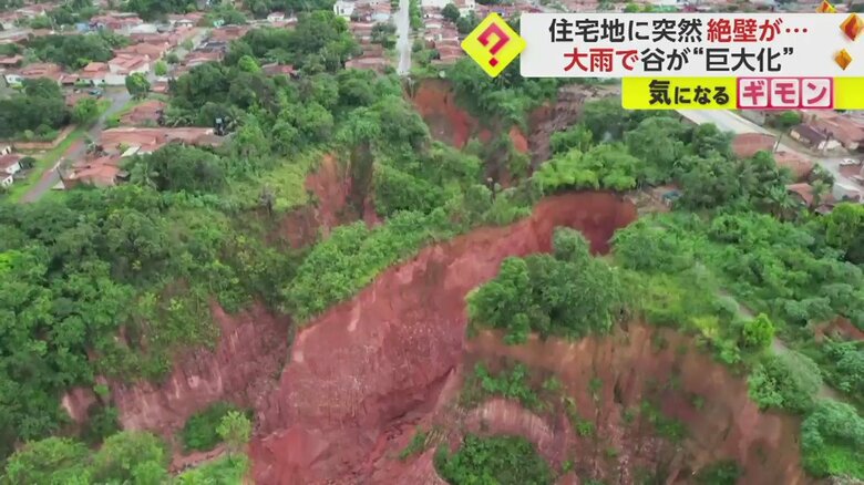 民家のそばに迫る、切り立った崖