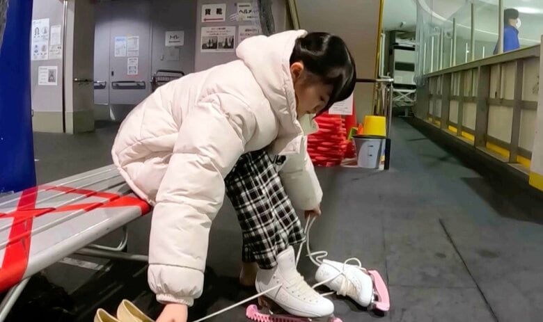 慣れた手つきでスケート靴をはく川﨑