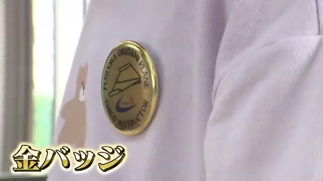 胸に輝く金バッジ