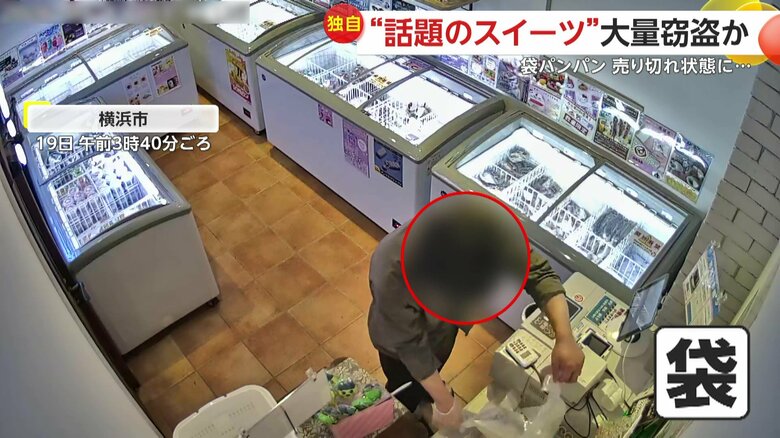 あふれんばかりの商品を袋に詰め込む男