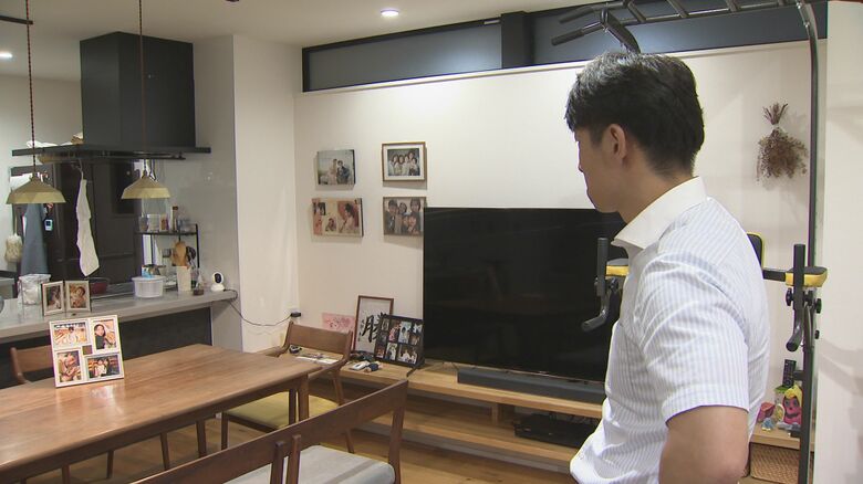 家族の写真を見る大間圭介さん