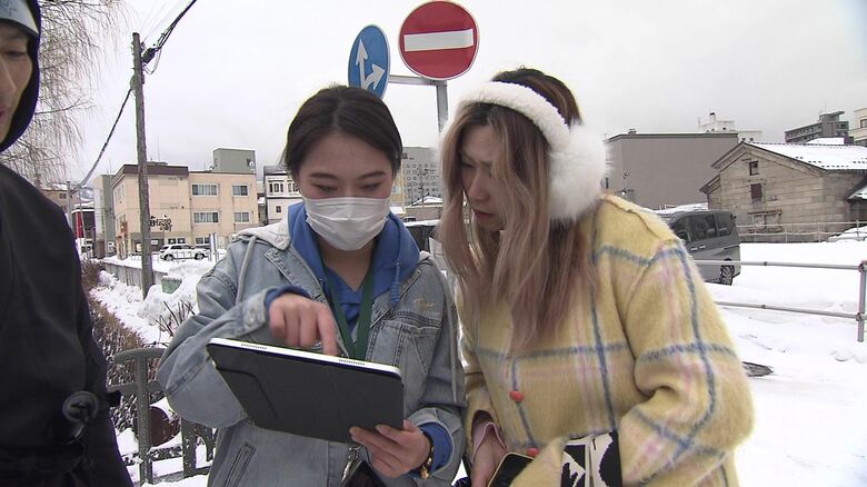 「忍者」のSNSを見る外国人観光客