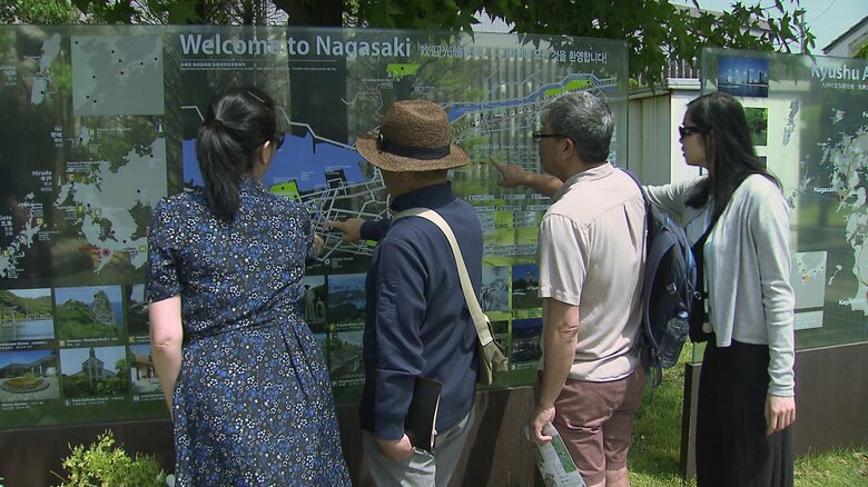 長崎市に設置された観光案内板を見るクルーズ客