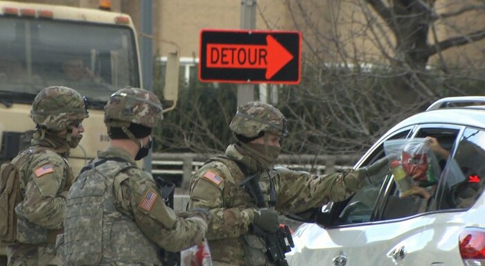 州兵にお菓子の差し入れを手渡す市民