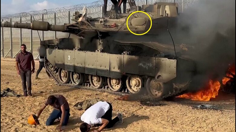 攻撃を受け燃えるメルカバMk.4M戦車　円内はトロフィー・アクティブ防護システムのレーダーアンテナ