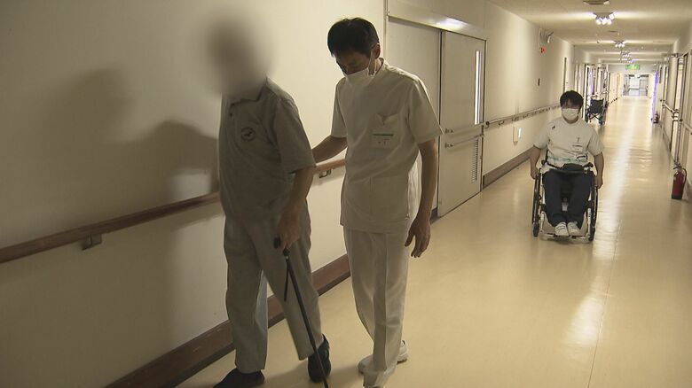 車いすに乗り、患者に声をかける加藤医師