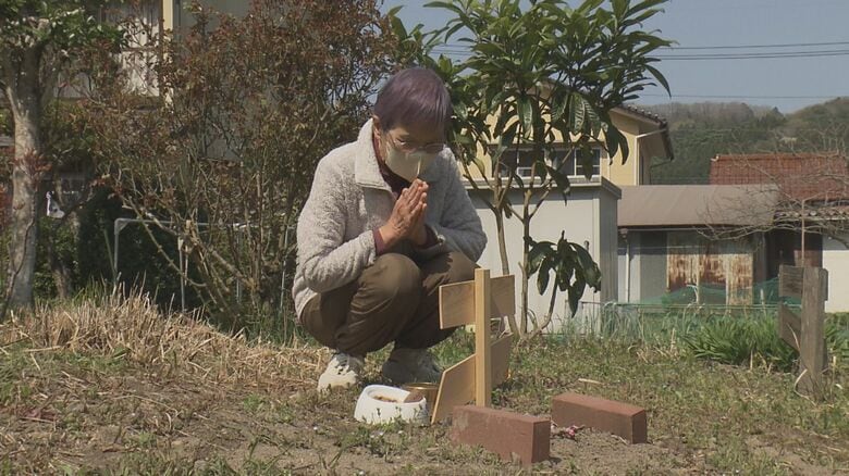 「コタロー」の墓に手を合わせる陶山さん