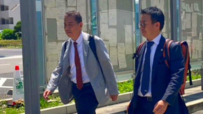 提訴する丸尾牧議員(写真左)