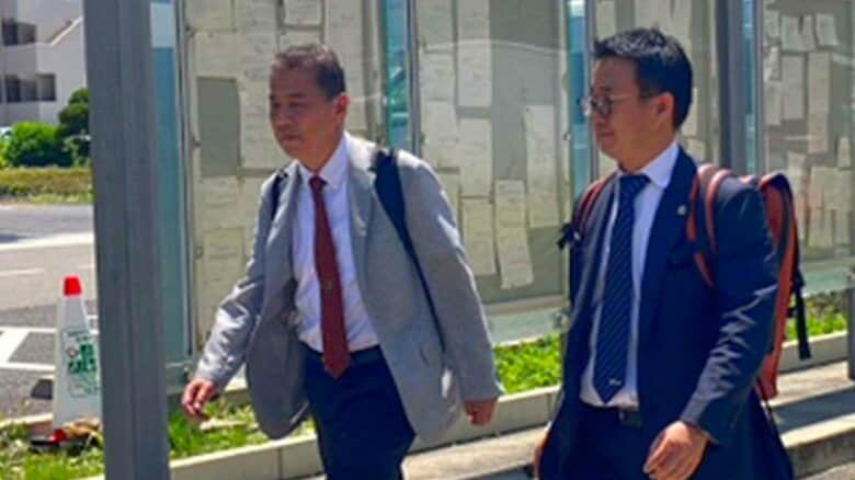 提訴する丸尾牧議員（写真左）