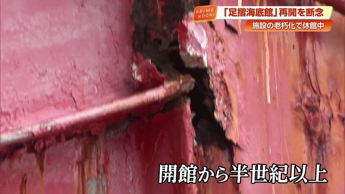 赤色の塗装が剥がれ、錆が目立つ連絡橋