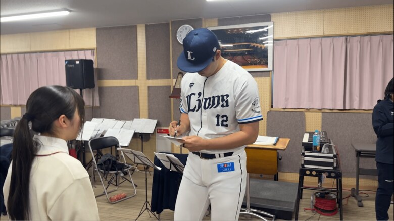 吹奏楽部の生徒にサインをする渡邉