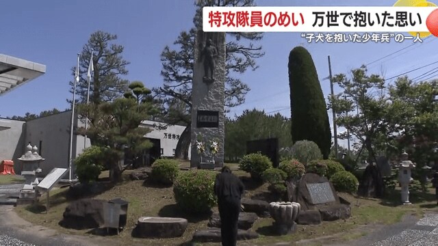 慰霊碑の前で手を合わせる高徳さん