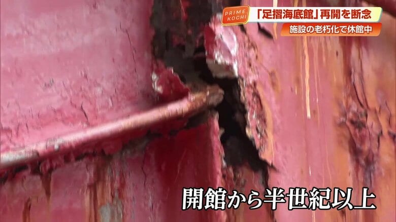 赤色の塗装が剥がれ、錆が目立つ連絡橋