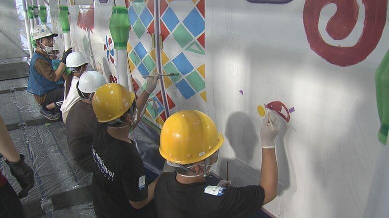 TAKAHIROさんデザインの列車に色を塗る佐世保市立広田小学校の子供たち（2022年）