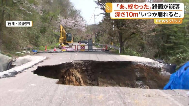 灰色のアスファルトをえぐるようにぽっかりと開いた茶色く巨大な穴