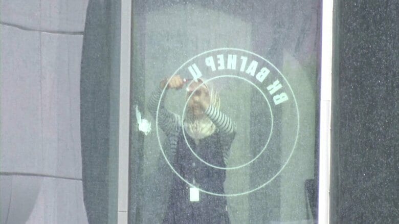 「ワグネル・センター」のステッカーを取り除く女性（サンクトペテルブルク・7月1日）