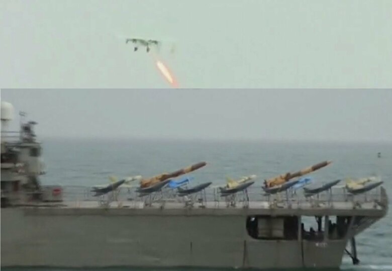 イラン海軍のヘンガム級車両揚陸輸送艦「ラバン」（画面下）の後甲板上に並ぶドローン。洋上を飛ぶドローン（画面上）