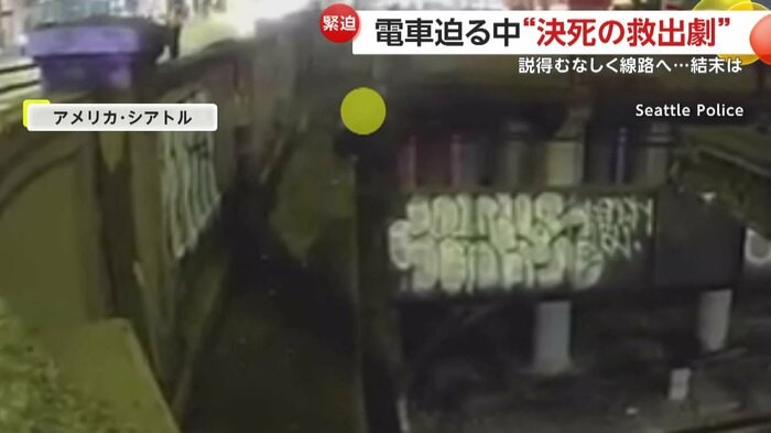 線路上の道路のへりに立っている男性