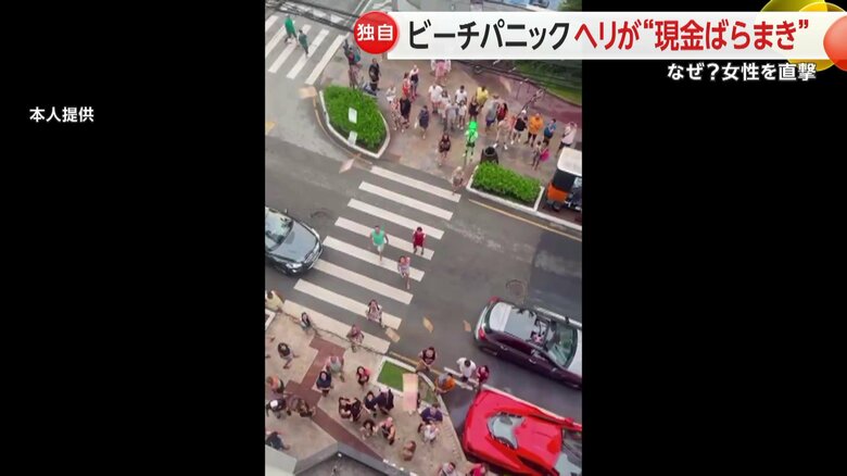 ホテルの窓からばらまかれたお金を拾う人々