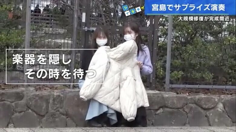 サプライズがバレないように楽器を隠す楽団メンバー