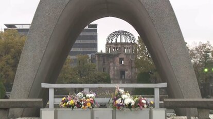 広島平和都市記念碑の向こうに原爆ドームを臨む