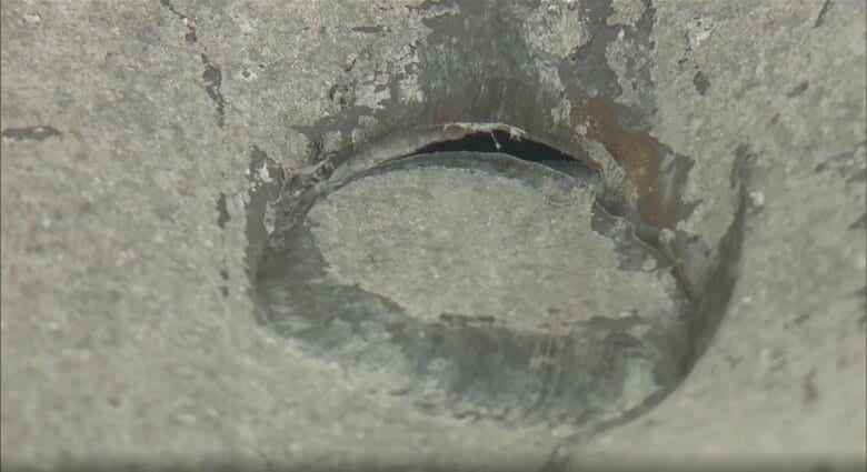 爆発地点から約40m離れた倉庫の壁にできた大きなへこみ