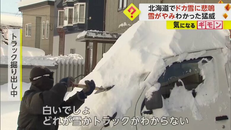 雪の中からトラックを掘り出している人