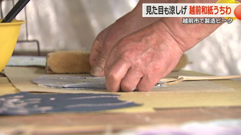 模様を付け乾燥させた和紙を、手作業でのり付けする