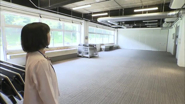 施設を案内する秋山結美さん(23)