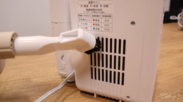 吸気口のホコリを掃除機で吸い取る（編集部撮影）
