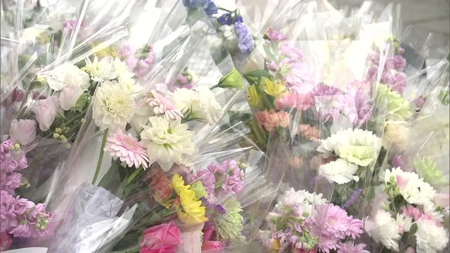 事故後、多くの人が花を手向ける