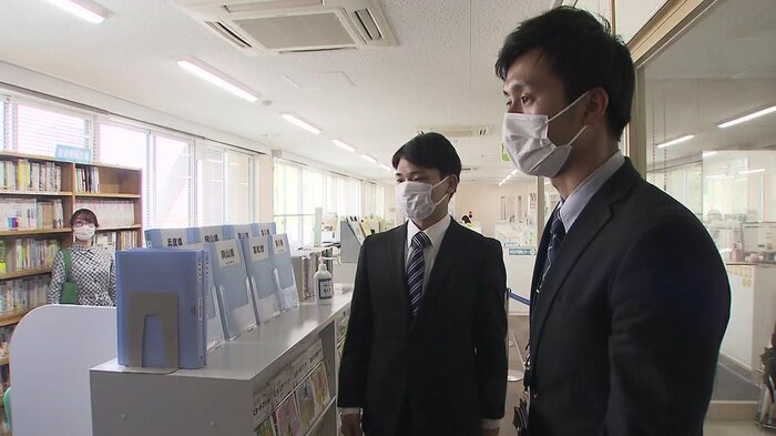 左:職員に案内される藤本智規さん