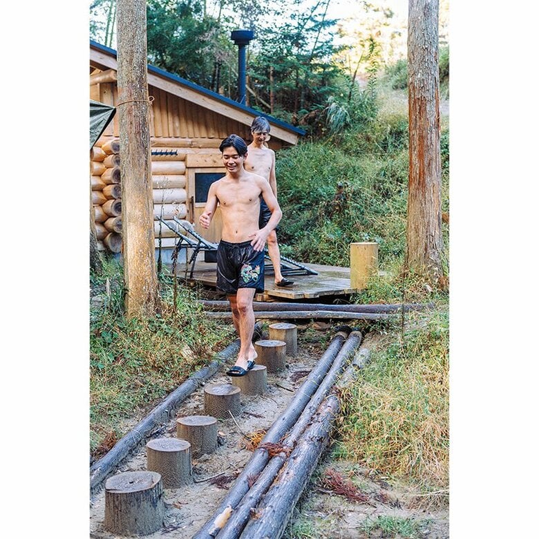 体に十分に熱が入ったら、小屋の外に出て川に向かう。飛び石のような丸太も渡邊さんが伐採したスギだ（『小屋を建てる』より）