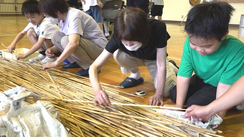 ヨシを使った天然素材のストローをつくる住民たち