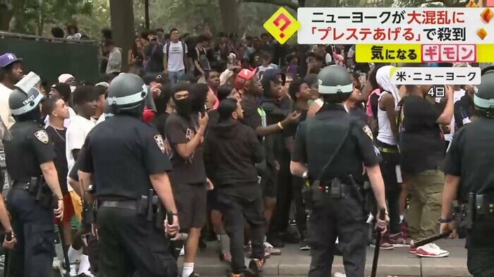 大勢の若者と警察が公園に集まっている