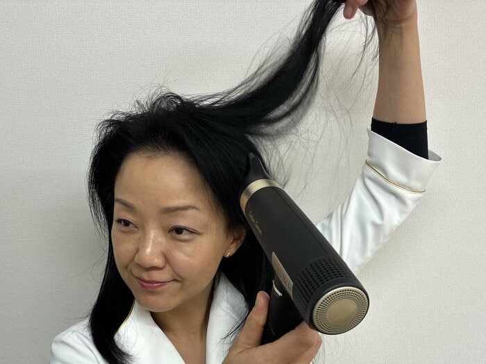 髪を持ち上げて頭皮にドライヤーの風を当てる（特集班撮影）