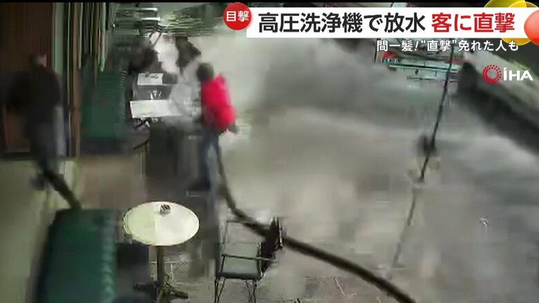 左右にホースを振り回している店主