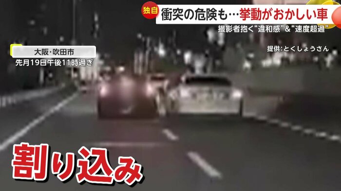 左から右の車線へ強引に割り込みする黒い車