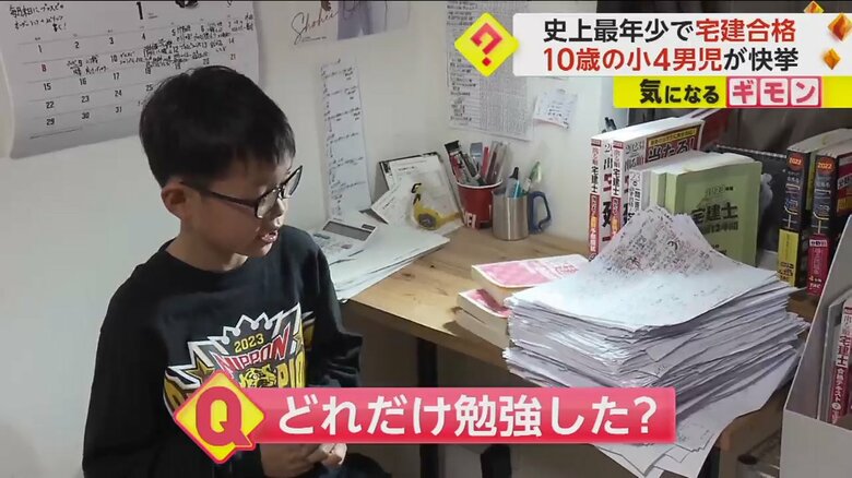 テキストやプリントが山積みになった机