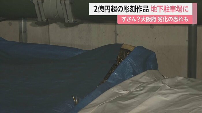ブルーシートがめくれて、作品の一部が見えてしまっている…