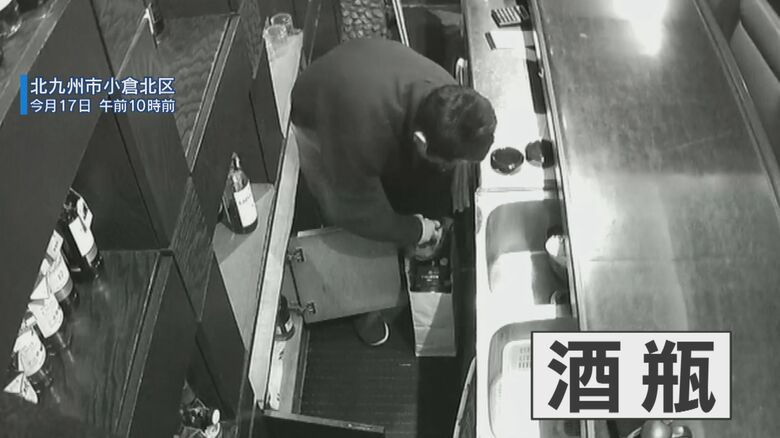 店の酒瓶を紙袋にいれる花井容疑者