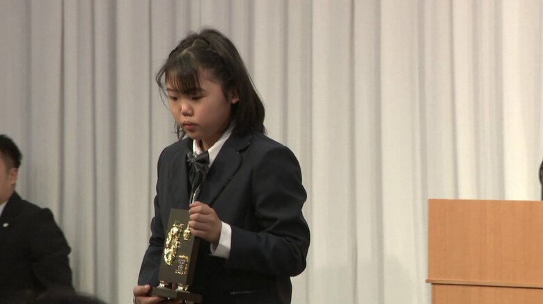 「辻ジュニアスポーツ賞」表彰式（3月・秋田市）で盾を手にする石澤さん