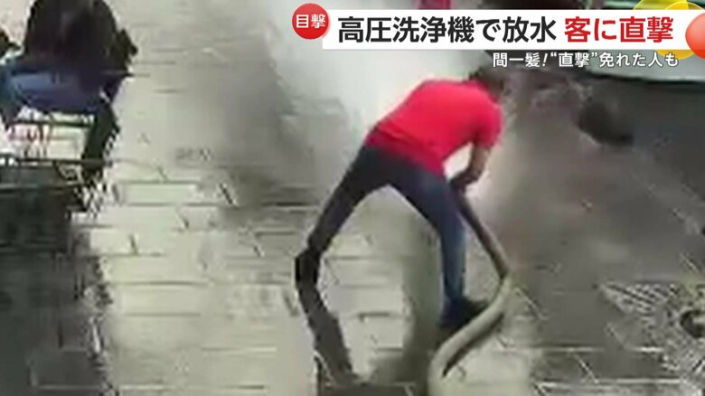 テラス席に客がいる中、店の前を高圧洗浄機で洗い始めていた店主
