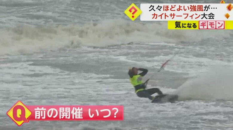 強風の中、大技を繰り出して着地するカイトサーフィンの選手