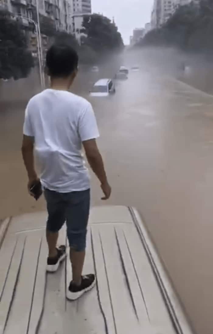 突然の濁流で立ち往生した男性は車の上で呆然。湖北省恩施市(ウェイボより)