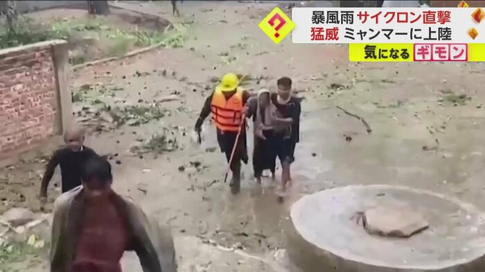両脇を支えられ避難する杖を持った女性