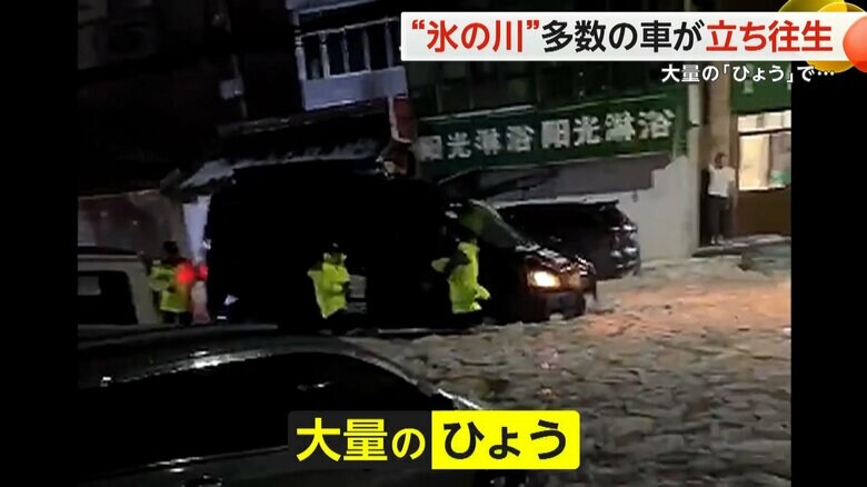 氷の塊に埋め尽くされた道路で動けなくなってしまった黒い車