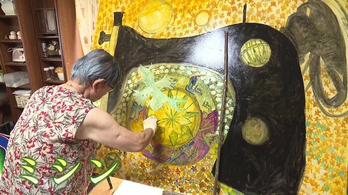 黒いミシンの絵を描く藤井節さん